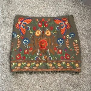 Embroidered skirt with pom pom detailing.